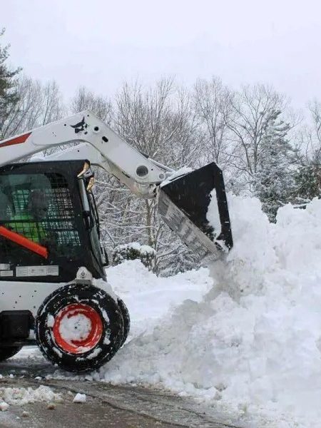 Skid steer stacking a snow pile for haul-off