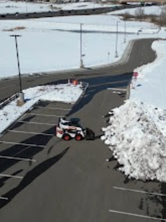 Treated commercial lot with snow stacked clear of the drive lanes
